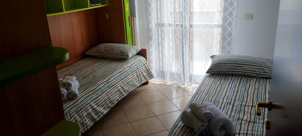 La seconda camera con i due letti singoli, l'armadio a ponte verde e la porta-finestra
