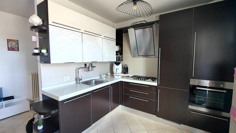 La cucina angolare vista dall'ingresso, con il piano cottura a gas e la cappa