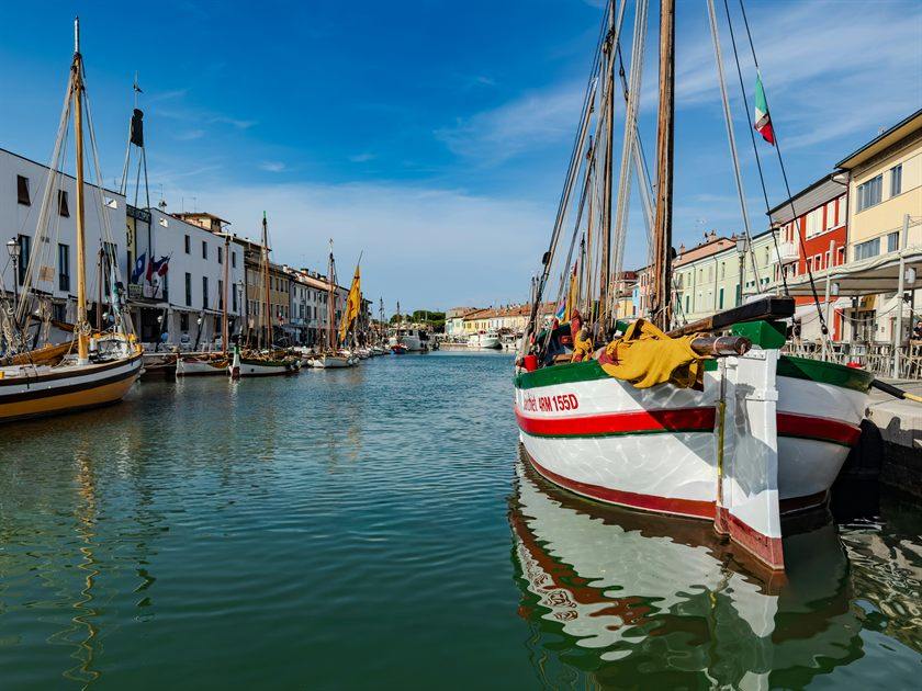 Barche a vela colorate ormeggiate nel porto canale di Cesenatico, fra le case del lungoporto